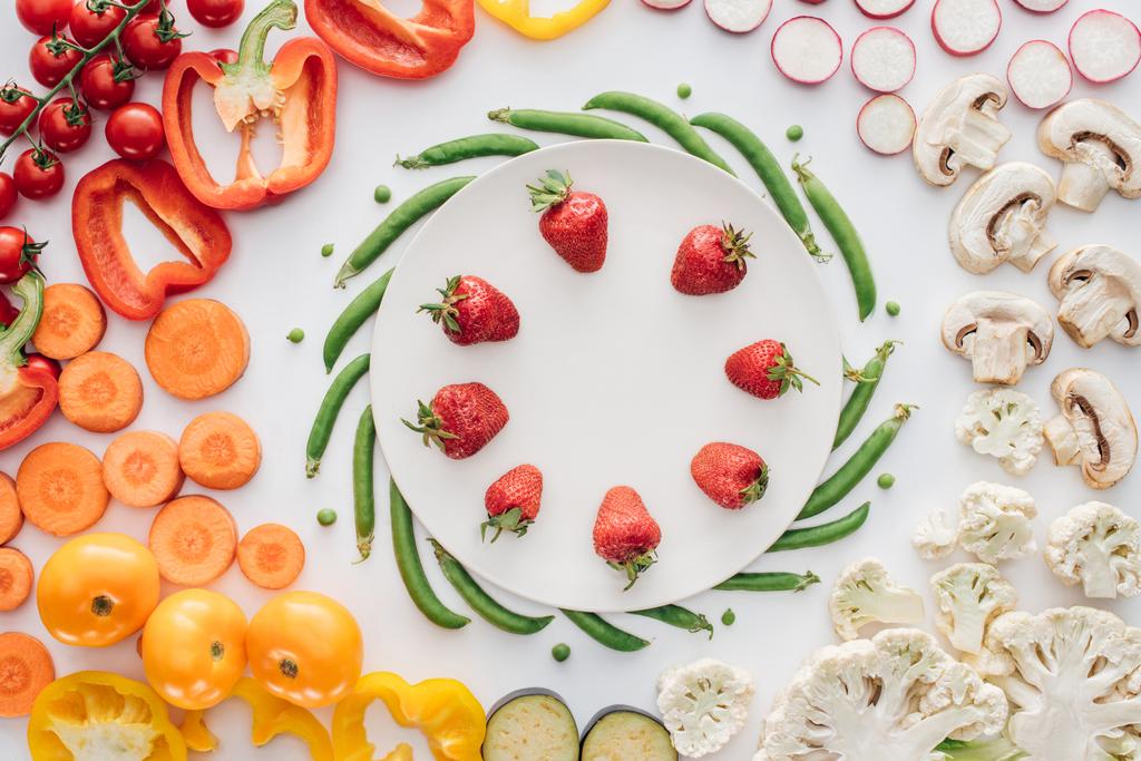 fraises fraîches mûres sur plaque ronde blanche et légumes biologiques isolés sur blanc
   - Photo, image