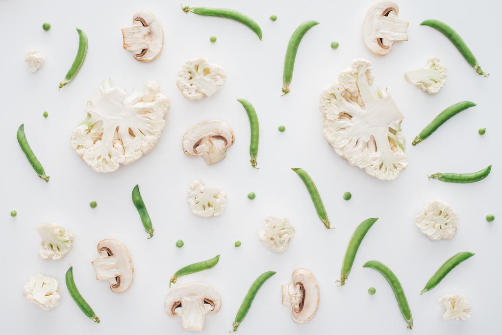 Draufsicht auf frisch geschnittenen Blumenkohl, Pilze und grüne Erbsen isoliert auf weißem Hintergrund - Foto, Bild