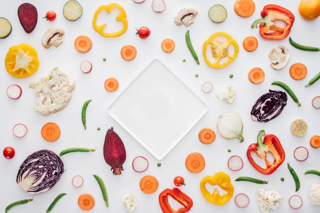 pohled shora z prázdné bílé desky a čerstvé nakrájené zeleniny, izolované na bílém  - Fotografie, Obrázek