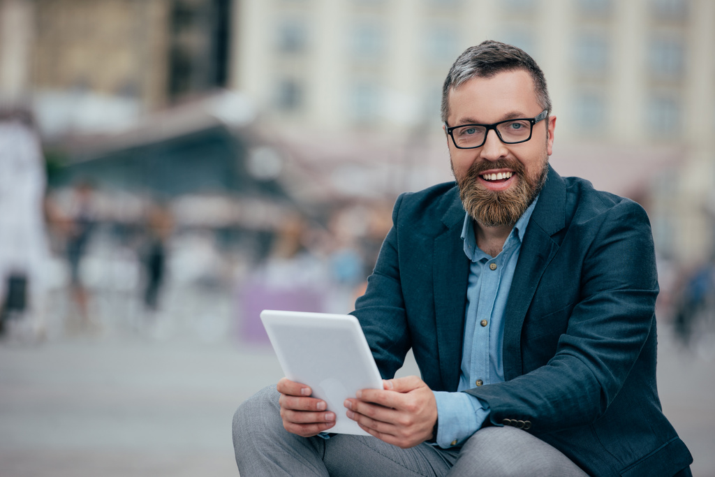 Bart stylischer Geschäftsmann in Brille mit digitalem Tablet in der Stadt - Foto, Bild