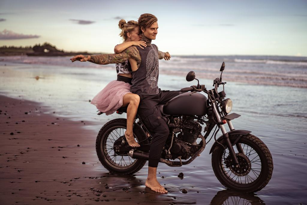 motosiklet ile oturan erkek silah okyanus plaj açın - Fotoğraf, Görsel