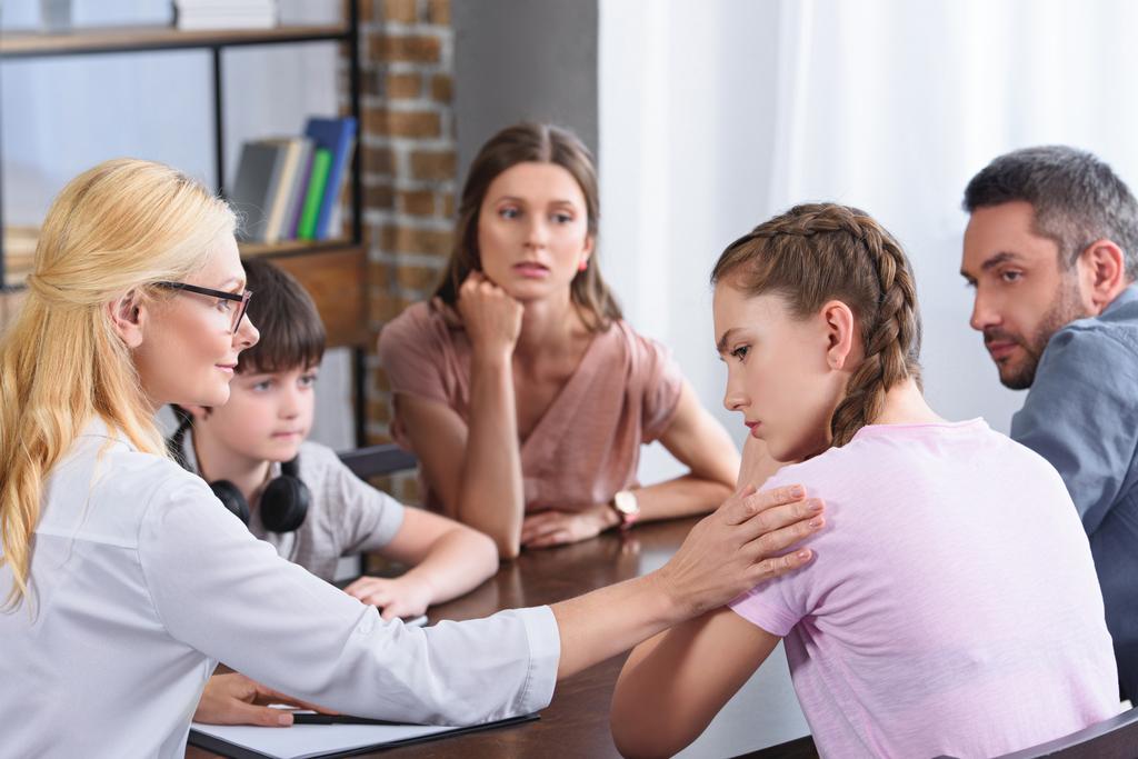 consejera femenina animando a la adolescente molesta en la sesión de terapia familiar en la oficina
  - Foto, imagen