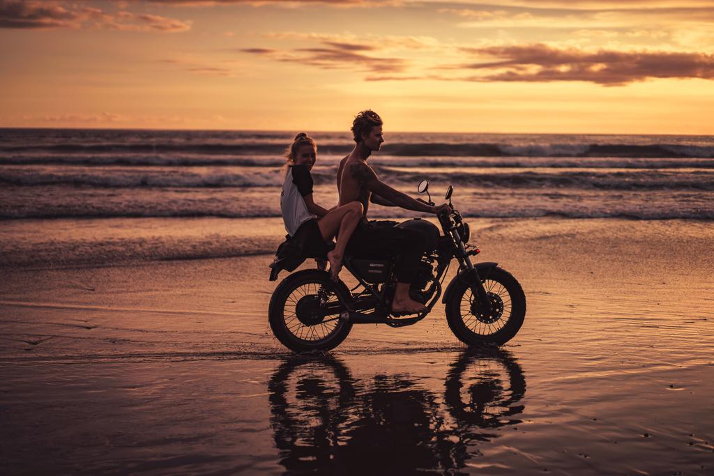 пара їде на мотоциклі на океанічному пляжі
  - Фото, зображення