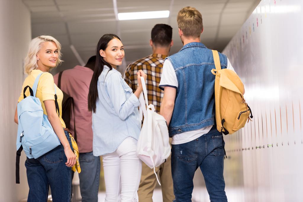 a fiatal diákok főiskolai folyosó gyaloglás hátsó nézet - Fotó, kép