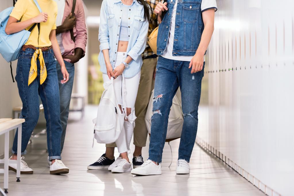 plan recadré de jeunes étudiants élégants debout ensemble dans le couloir du collège
 - Photo, image