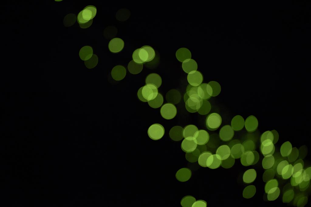 kaunis kiiltävä vihreä defocused bokeh mustalla taustalla
 - Valokuva, kuva