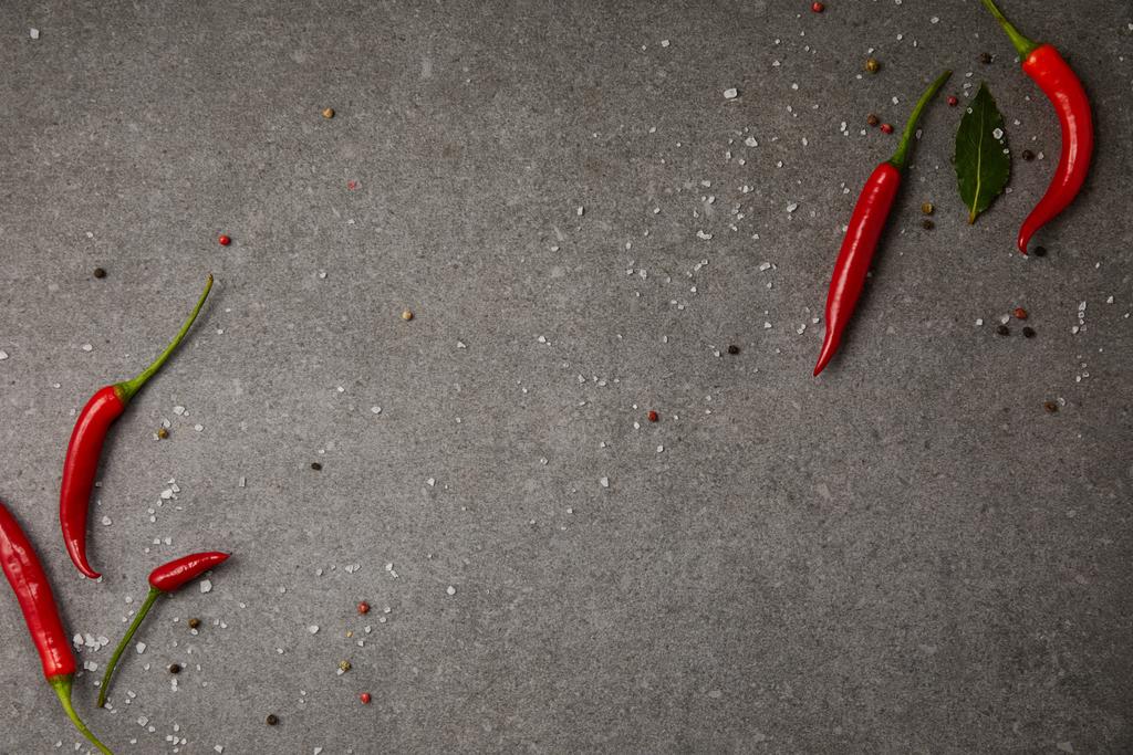 szürke asztalon szétszórt fűszerek és chili paprika felülnézet - Fotó, kép