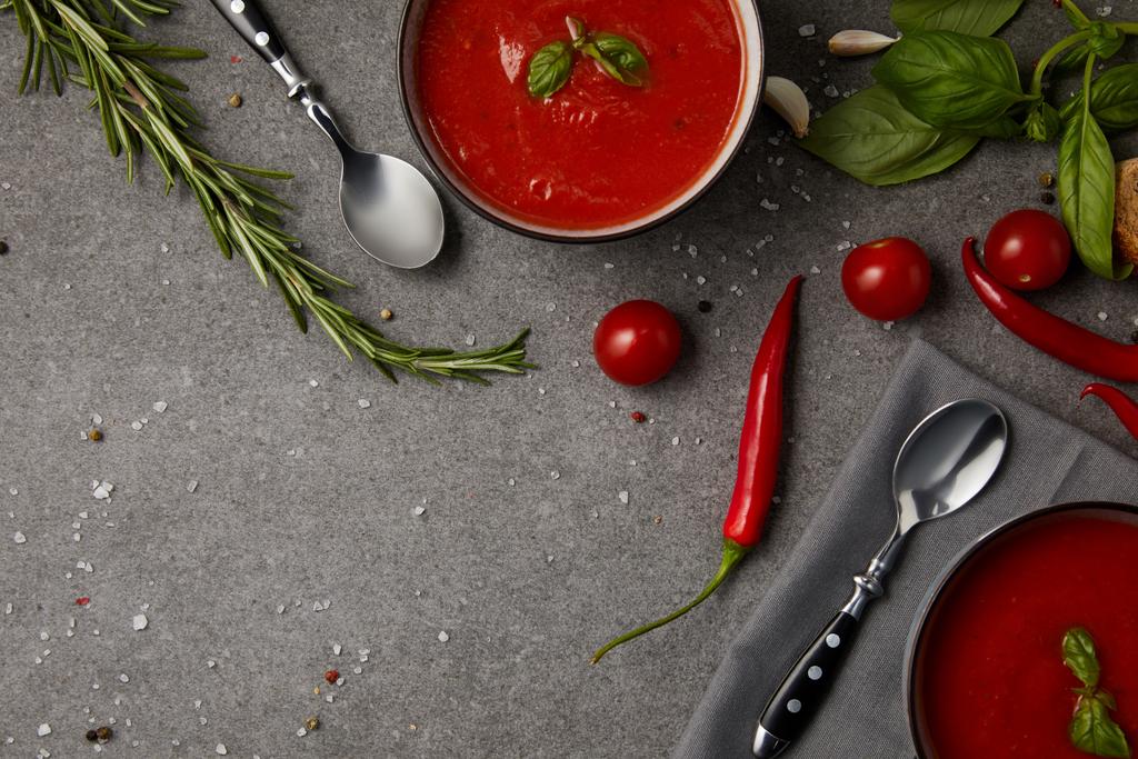 vista superior de los platos con sabrosa sopa de tomate y tomates frescos en la mesa gris
 - Foto, Imagen