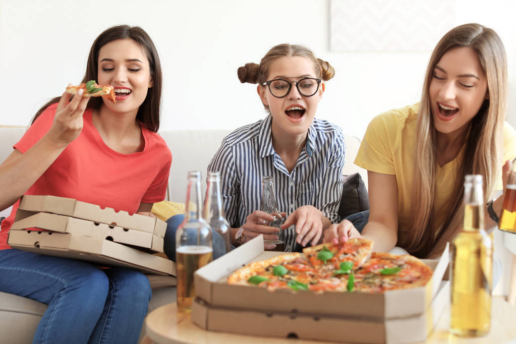Молодые люди веселятся с вкусной пиццей в помещении
 - Фото, изображение