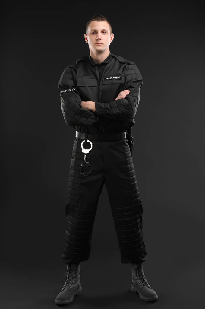 Αρσενικό φρουρά ασφάλειας σε ομοιόμορφη σε σκούρο φόντο - Φωτογραφία, εικόνα