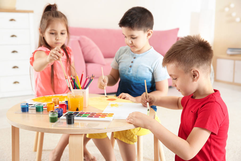 Lindos niños pequeños pintando en la mesa en la sala de juegos
 - Foto, Imagen