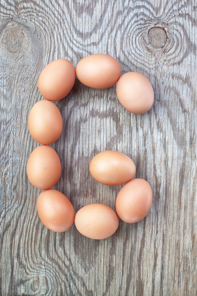 uma letra g partir os ovos para a Páscoa. em uma textura de madeira. - Foto, Imagem