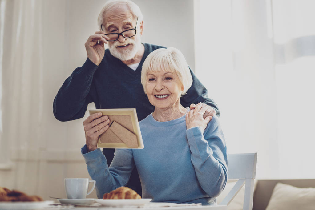 Nice elderly couple looking at the family photo - Photo, Image