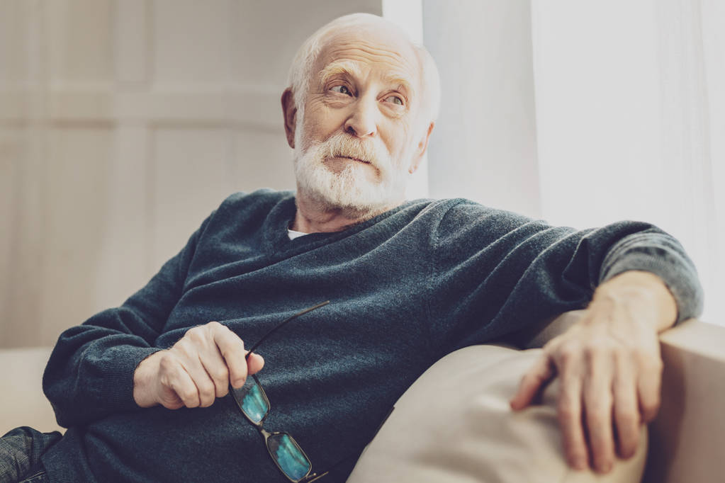 Homem idoso agradável sentado em casa
 - Foto, Imagem