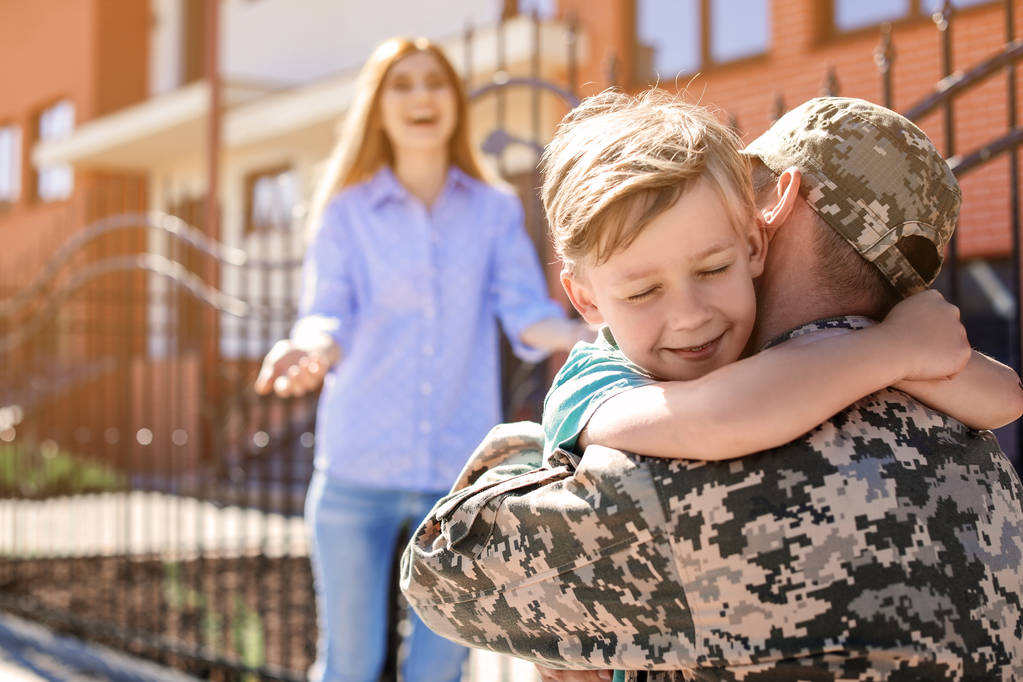 屋外に彼の息子を抱いて男性兵士。軍事サービス - 写真・画像