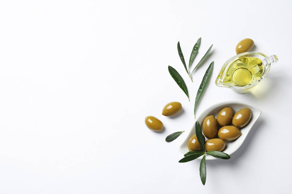 Kaunis koostumus öljyllä ja kypsillä oliiveilla valkoisella taustalla
 - Valokuva, kuva