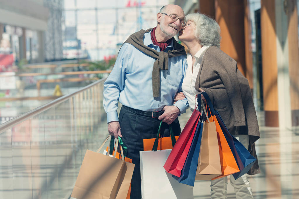 Adult senior couple with purchases in bags at shopping mall - Photo, Image
