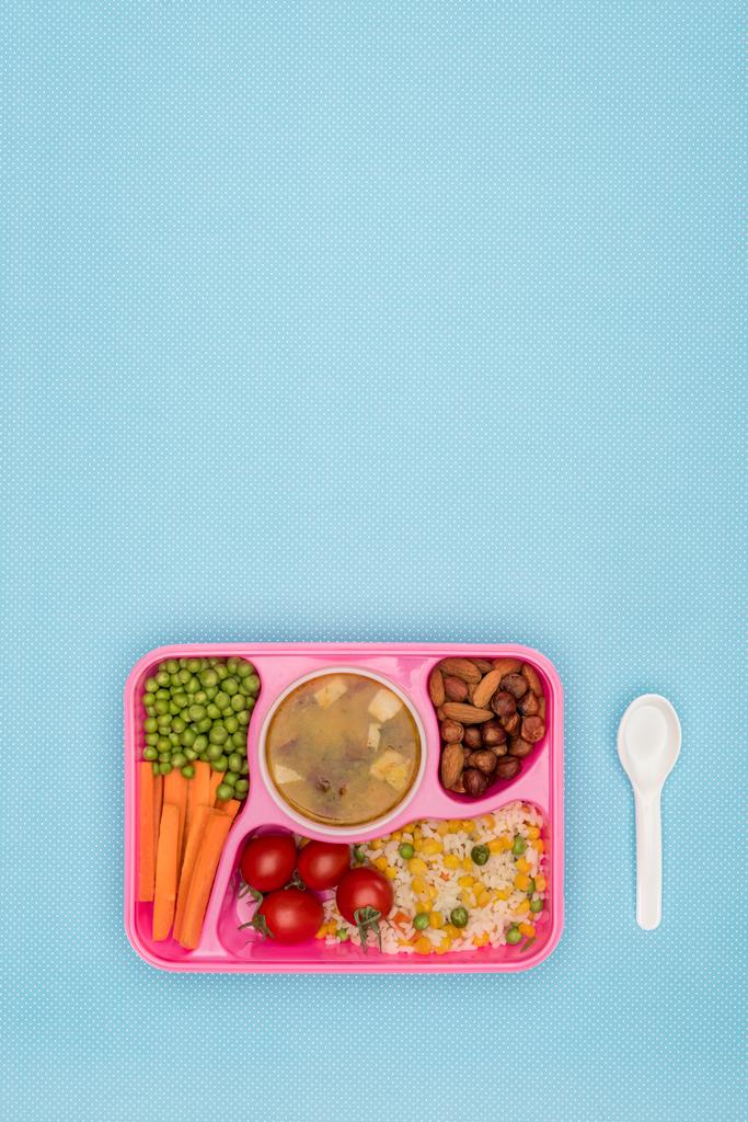 top view of tray with kids lunch for school and spoon isolated on blue - Photo, Image