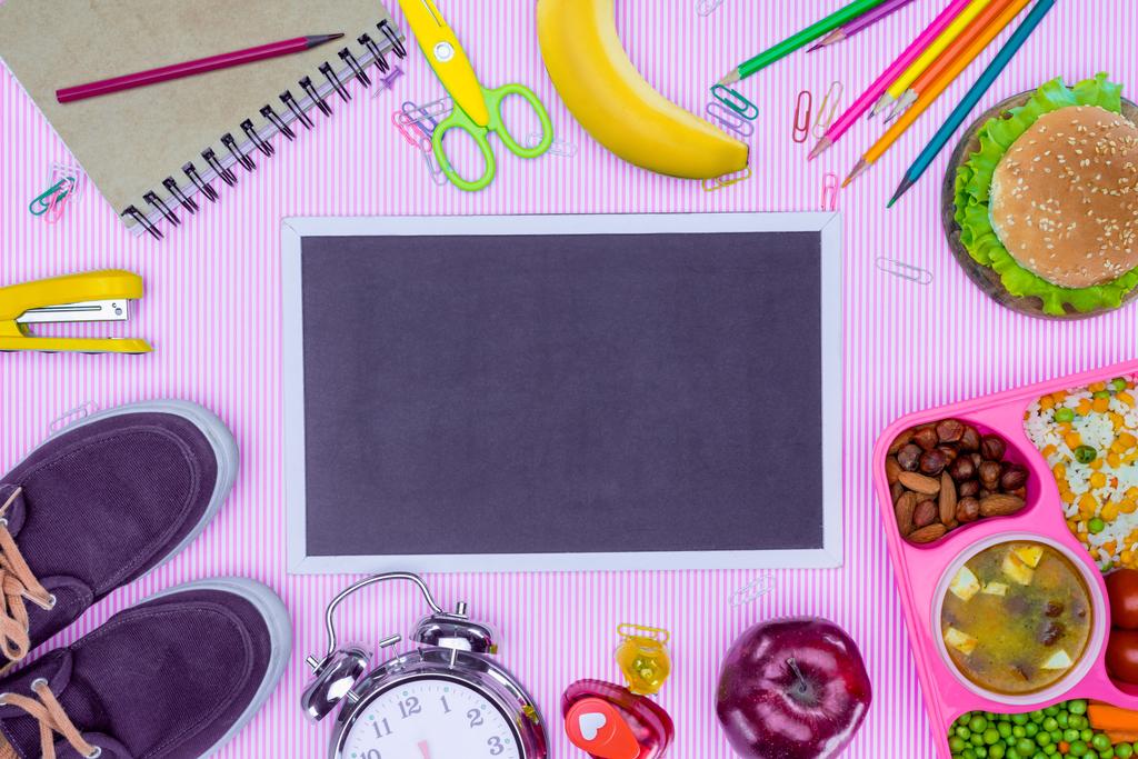 Draufsicht auf Tafel und Tablett mit Schulessen für Kinder auf violetter Oberfläche - Foto, Bild