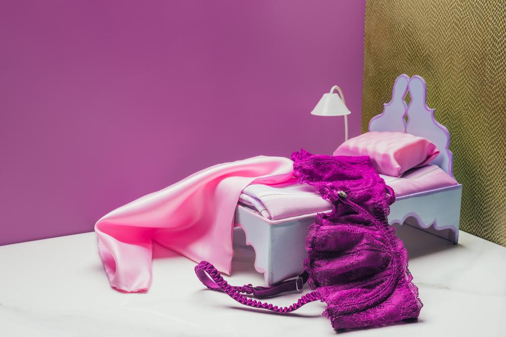 Toy κρεβάτι και δάδας λαμπτήρας με πραγματικό μέγεθος σουτιέν σε μικροσκοπικό δωμάτιο - Φωτογραφία, εικόνα