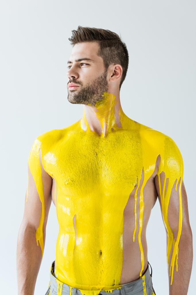 junger Mann mit gelber Farbe auf weißem Hintergrund abgedeckt - Foto, Bild