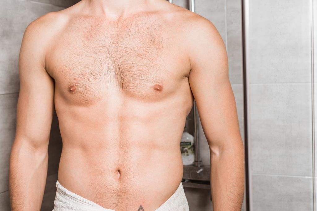 Vista ritagliata del corpo maschile nudo sotto la doccia
 - Foto, immagini