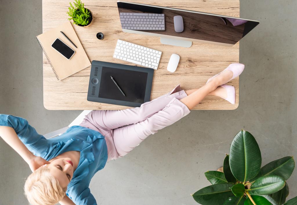 şık kadın teleworker ayaklı bilgisayar, akıllı telefon ve grafik tablet evde masada oturan havai görünümü  - Fotoğraf, Görsel