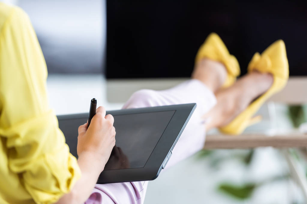 обрізане зображення фрілансера жінки з використанням графічного планшета за столом з комп'ютером в домашньому офісі
  - Фото, зображення