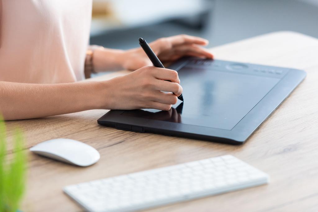 обрізане зображення жіночого фрілансера, що малює на графічному планшеті за столом в домашньому офісі
  - Фото, зображення
