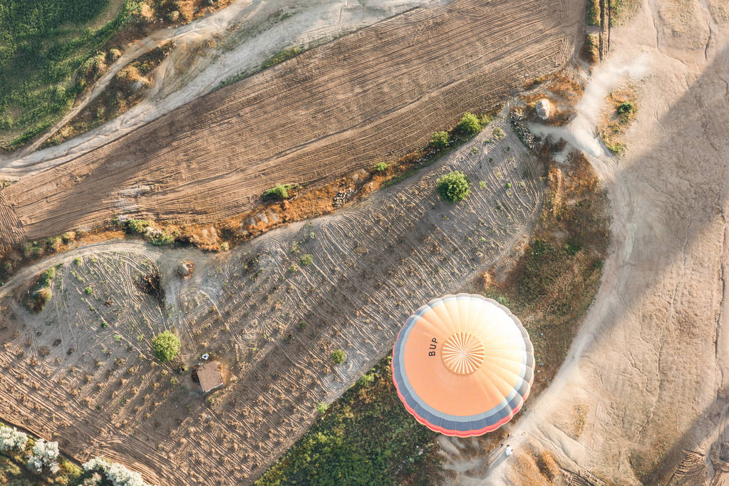 top view of hot air balloon flying above majestic landscape in cappadocia, turkey  - Photo, Image