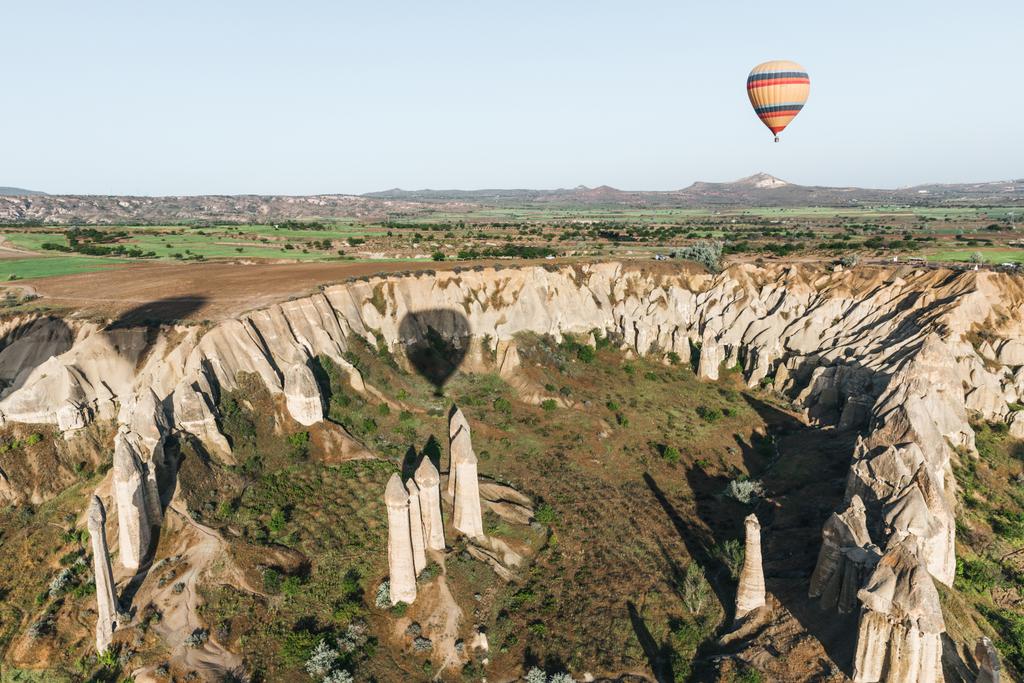 Heißluftballon fliegt über schöne berühmte Felsformationen in Kappadokien, Türkei - Foto, Bild