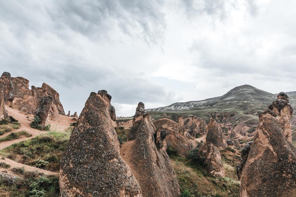 majestueuze geologische formaties en bewolkte hemel in Cappadocië, Turkije - Foto, afbeelding