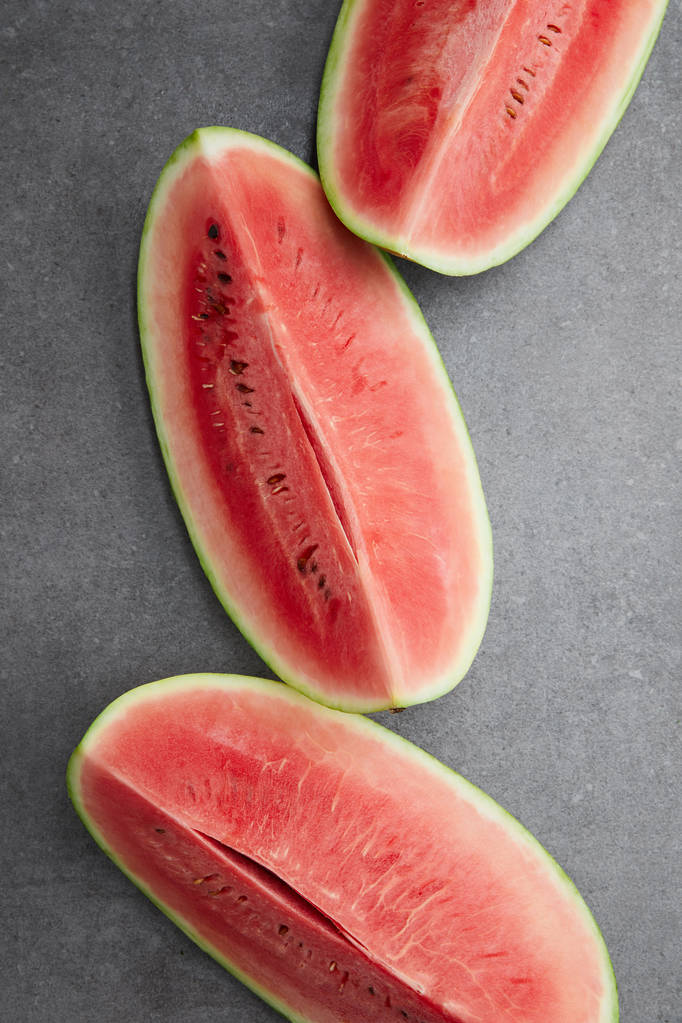 flat lay with arranged watermelon pieces on grey concrete tabletop - Photo, Image