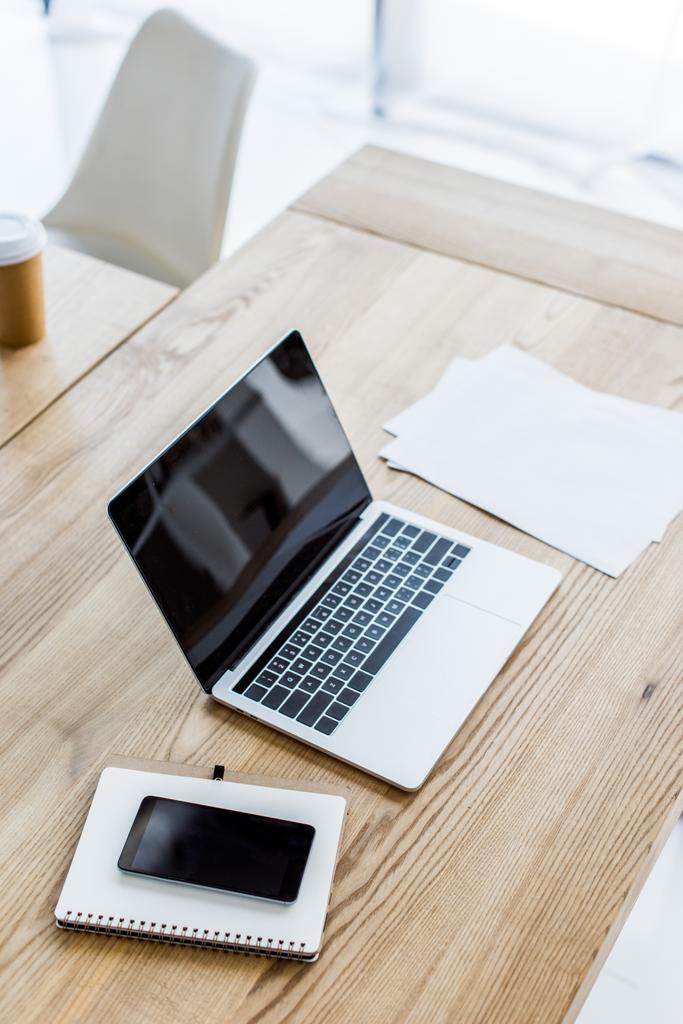 Blick auf Laptop, Smartphone und Notebook auf dem Tisch im Büro - Foto, Bild