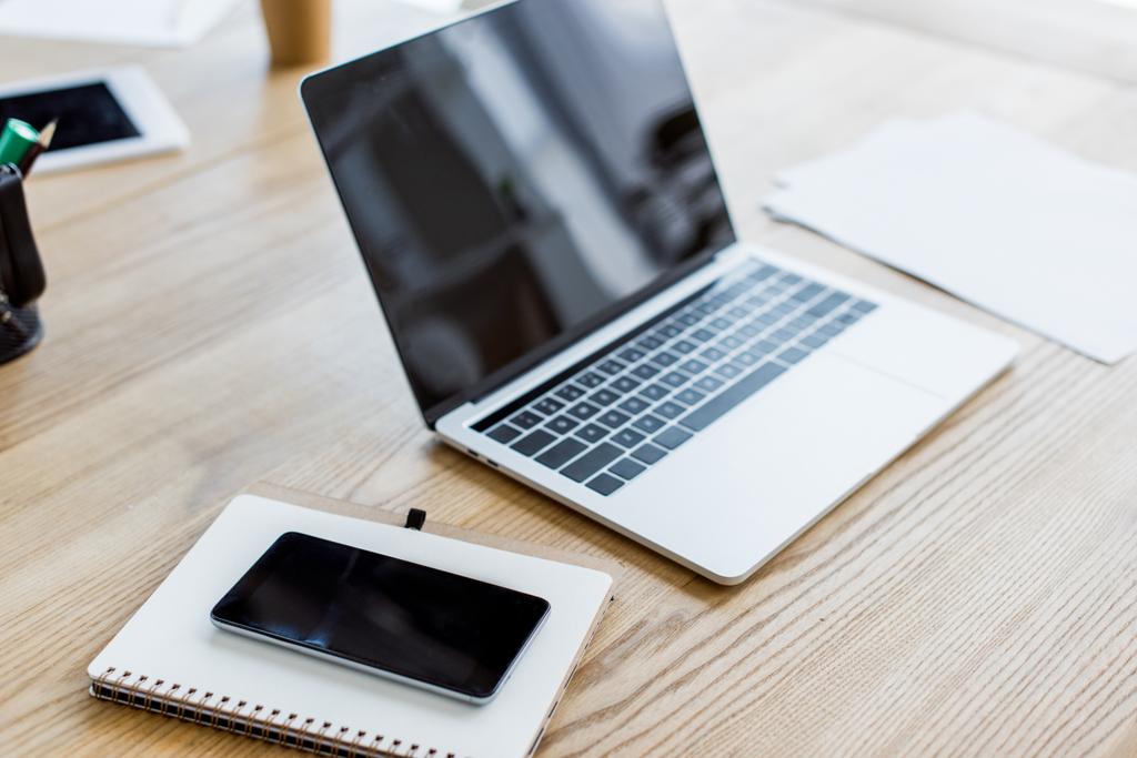 laptop, smartphone e notebook na mesa no escritório de negócios
 - Foto, Imagem