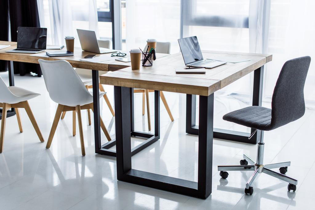 інтер'єр бізнес-офісу з ноутбуками на столах
  - Фото, зображення