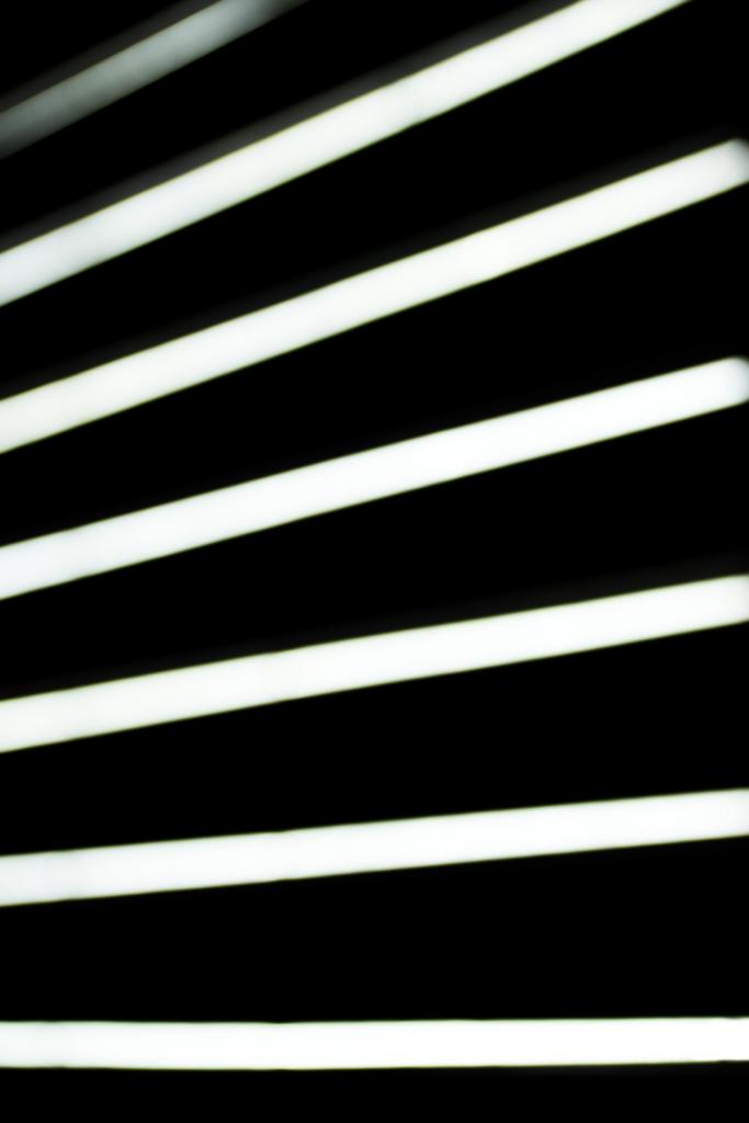 Nahaufnahme von verschwommenen weißen Blitzlampen auf schwarzem Hintergrund - Foto, Bild