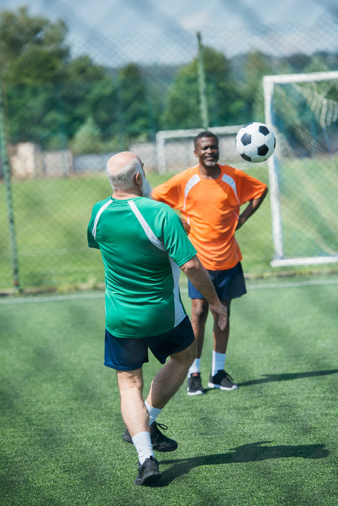 çok ırklı yaşlı adamlar futbol birlikte yeşil sahada oynayan - Fotoğraf, Görsel