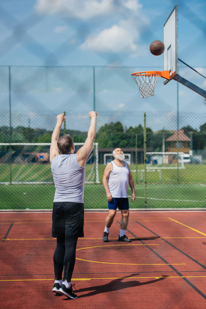 高齢者男性の夏の日の遊び場で一緒にバスケット ボールをプレー - 写真・画像