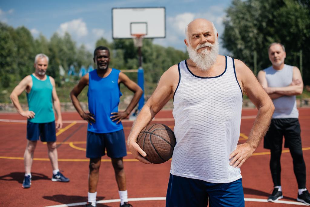 çok ırklı yaşlı sporcular oyun basketbol topu ile seçici odak - Fotoğraf, Görsel