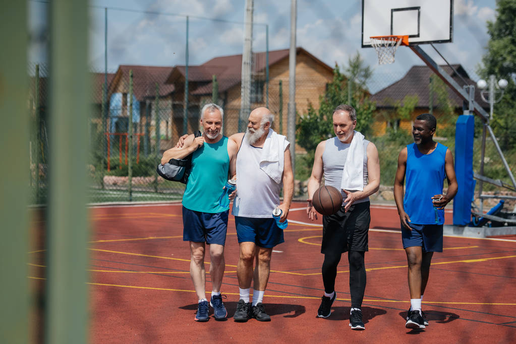 мультиэтнические пожилые спортсмены с баскетбольным мячом на детской площадке
 - Фото, изображение