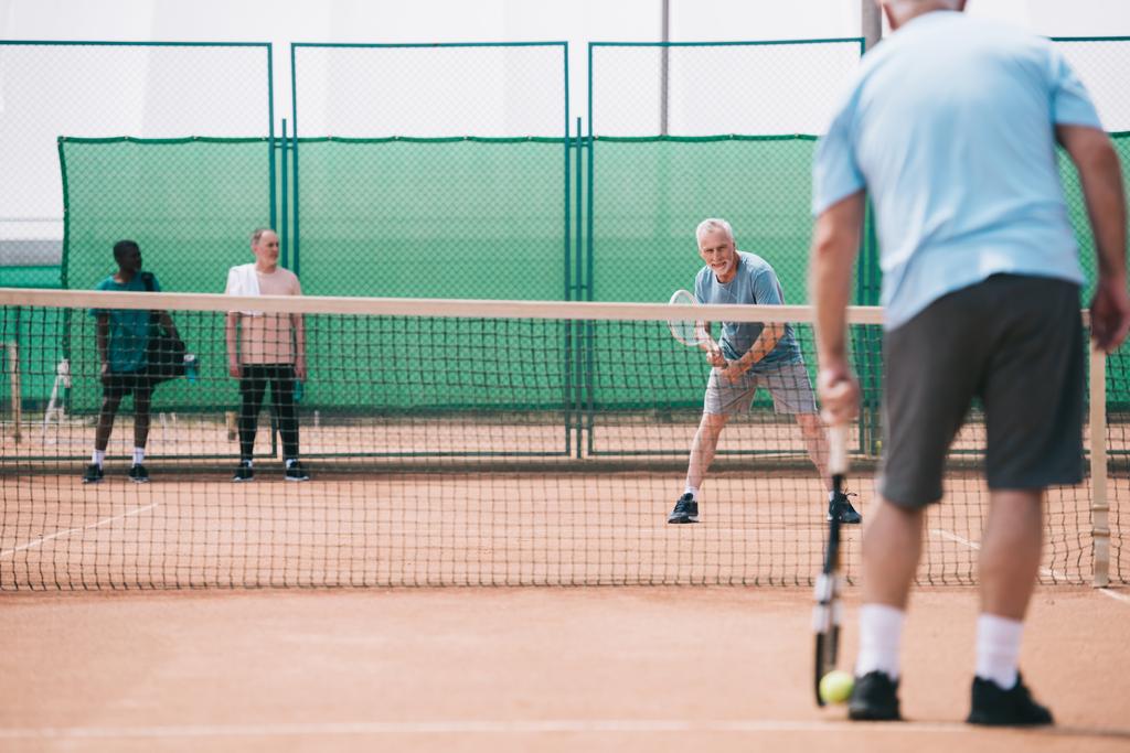Selektivní fokus starých sportovců hrát tenis na kurtu - Fotografie, Obrázek