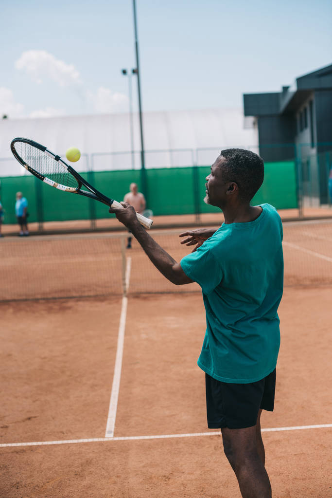 selectieve aandacht voor oudere Afro-Amerikaanse man tennissen met vriend op Hof - Foto, afbeelding