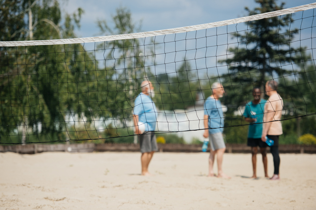 Selektivní fokus čisté a smíšené rasy dědků s volejbalový míč na písečné pláži - Fotografie, Obrázek