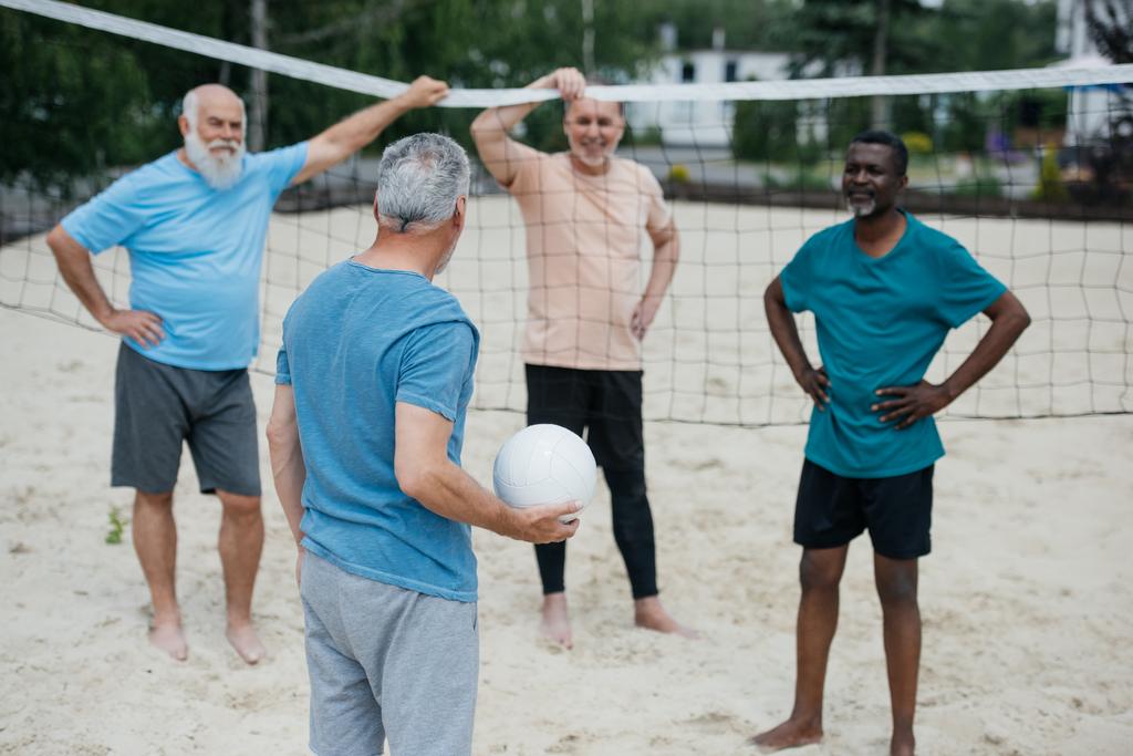 multicultural old friends playing volleyball on beach on summer day - Photo, Image