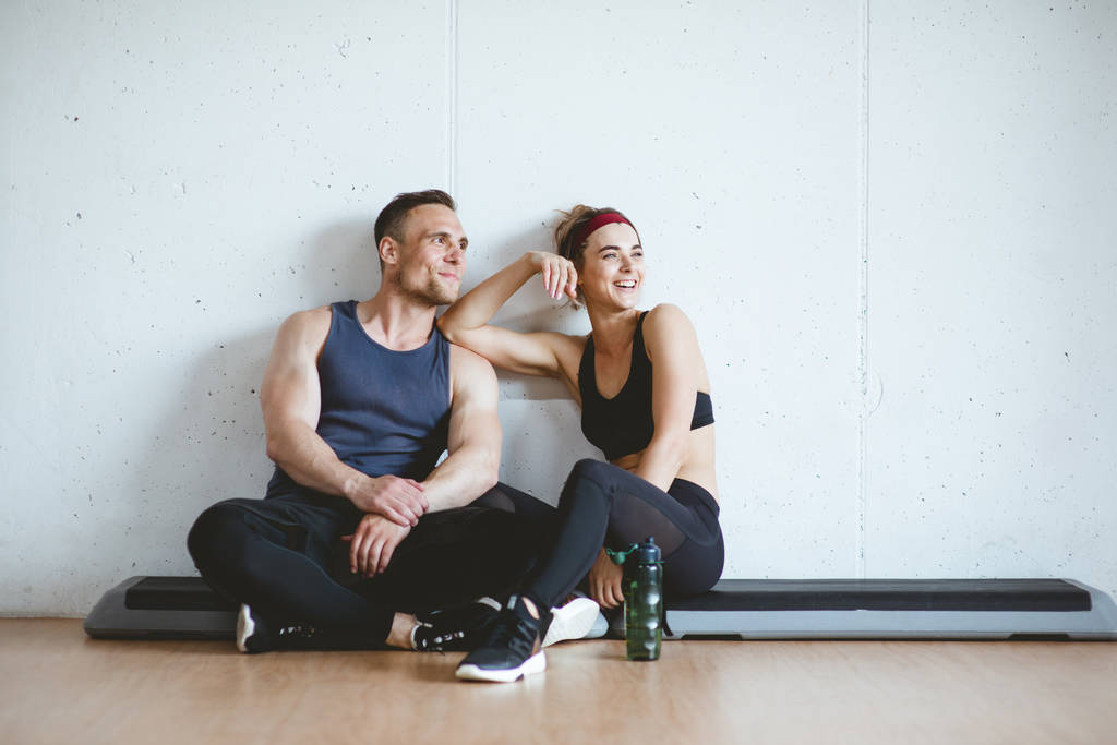 Sportler-Paar lächelt nach gutem Training im Fitnessstudio. Sportliches Fitnessstudio-Konzept - Foto, Bild