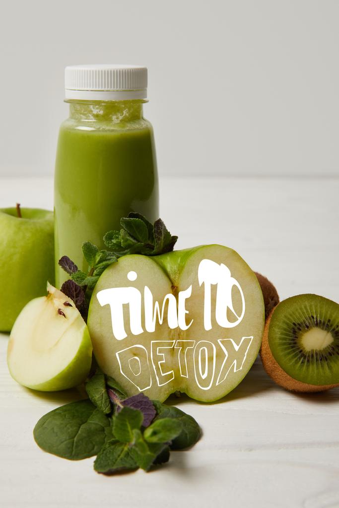 láhev zelené detoxikační koktejl s mátou a jablka, kiwi a na bílý dřevěný povrch, čas na detox nápis - Fotografie, Obrázek