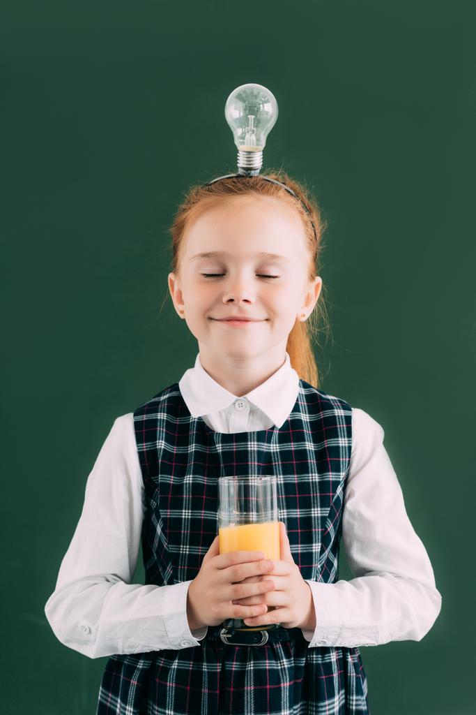 目を閉じてとオレンジ ジュースのガラスを保持している頭の上の電球幸せ小さな女子高生 - 写真・画像