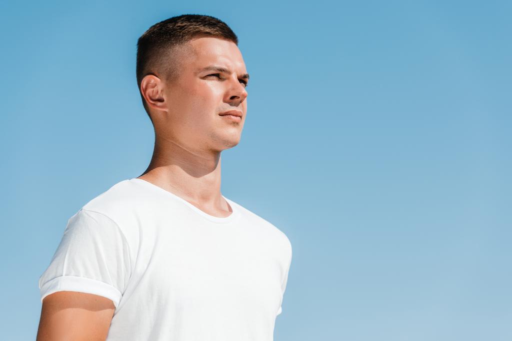 side view of young soldier in white shirt against blue sky - Photo, Image