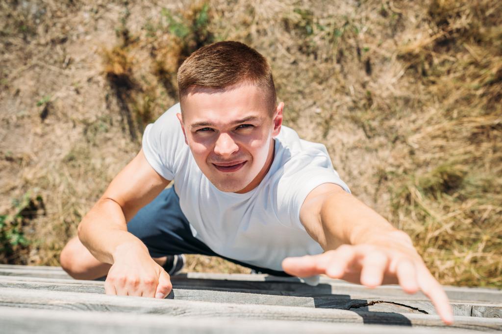 pohled z mladého vojáka lezení dřevěné závory během překážka spustit v rozsahu - Fotografie, Obrázek